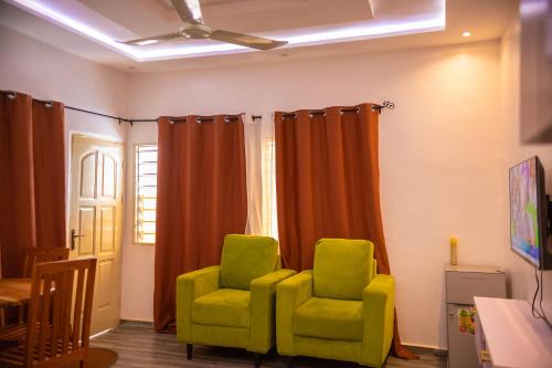 two green chairs sitting in a living room at Mag home in Porto-Novo