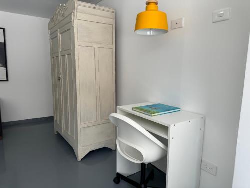 a white desk with a chair and a cabinet at Ope Suites calle 100 in Bogotá