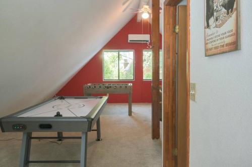 a ping pong table in a room with a red wall at Evergreen Dorrington Chalet - Family Fun & Game Rm in Dorrington