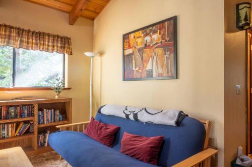 a blue couch with red pillows in a living room at Evergreen Dorrington Chalet - Family Fun & Game Rm in Dorrington