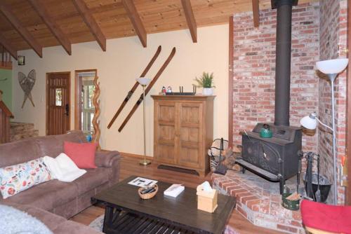 a living room with a couch and a wood stove at Evergreen Dorrington Chalet - Family Fun & Game Rm in Dorrington