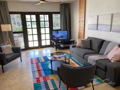 a living room with a couch and a tv at CABARETE BEACH HOUSES the NANNY ESTATES in Cabarete