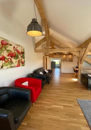a living room with couches and a red couch at Ferienhaus am Bach in Achslach