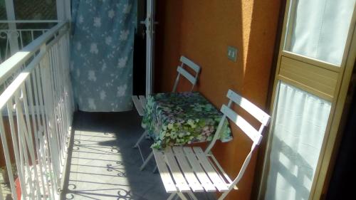 a porch with two chairs and a table on a balcony at Agriturismo la Terra di Mezzo in Castellamonte