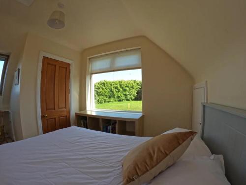 The Little Haven On The Cliff في هاوثْ: غرفة نوم بسرير كبير مع نافذة