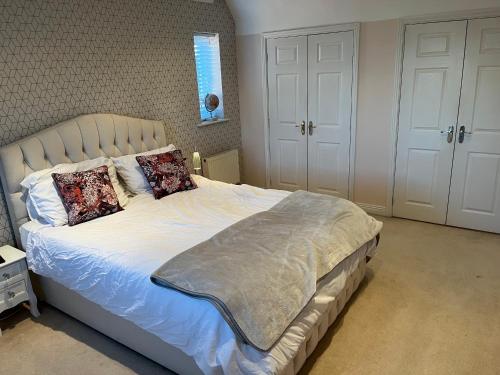 a bedroom with a large bed with two pillows at Pennymoor in Middlewich