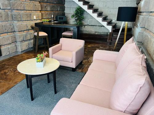 a living room with a couch and a chair and a table at QA Hotel in San Luis Potosí