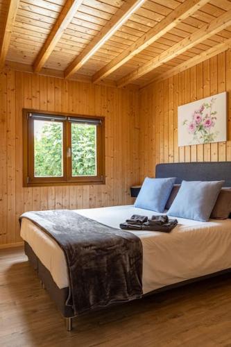 a bedroom with a large bed in a room with wooden walls at Porto Maia Garden in Maia