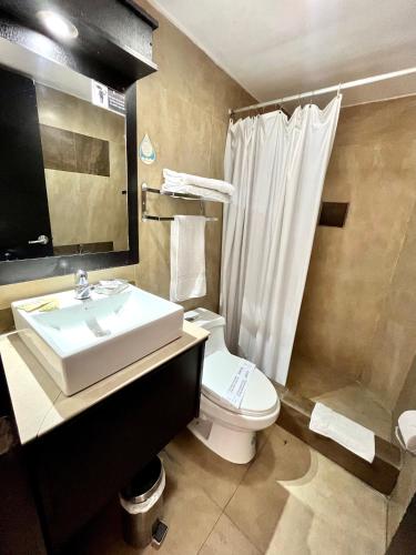 un bagno con lavandino, WC e doccia di Hotel Imperial ad Ambato