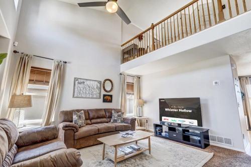 a living room with a couch and a tv at Whistler Hollow! Family Home, Bball Court, Firepit in Colorado Springs