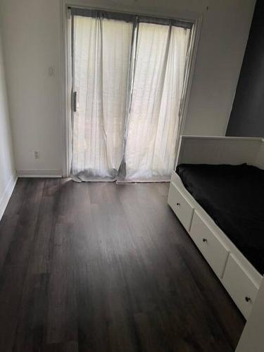 a bedroom with a bed and a large window at Quaint and Cozy Haven in Toronto