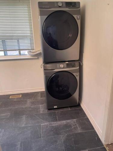 two microwaves sitting on top of a washing machine at Quaint and Cozy Haven in Toronto