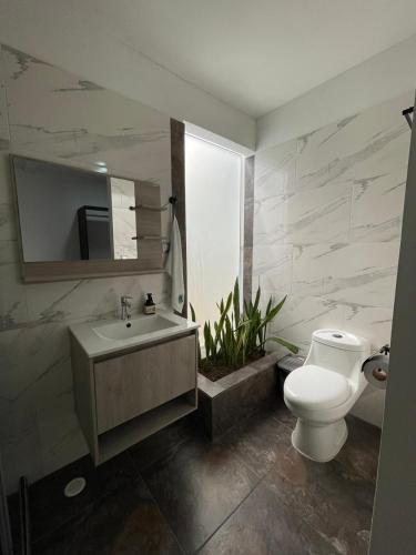 a bathroom with a white toilet and a sink at Casa Patio Bonito - Los Prados in Mocoa