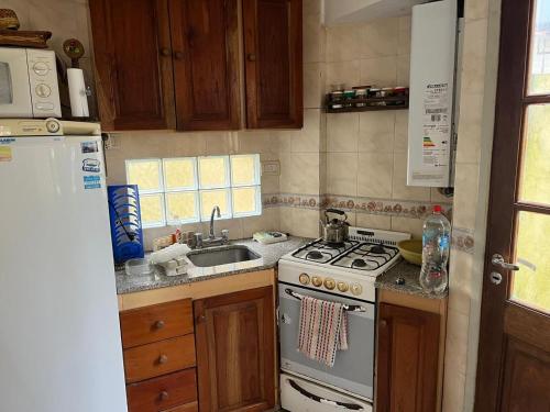 eine Küche mit Herd und Spüle in der Unterkunft Duplex frente al Mar en Villa Gesell in Villa Gesell