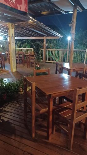 a wooden table and chairs on a wooden deck at Pousada Miracolo in Paraty