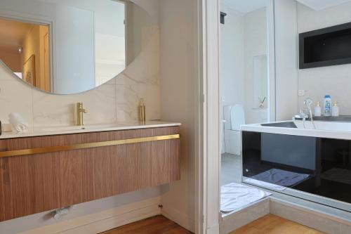 a bathroom with a sink and a mirror at Erawan Boutique Hôtel in Évreux