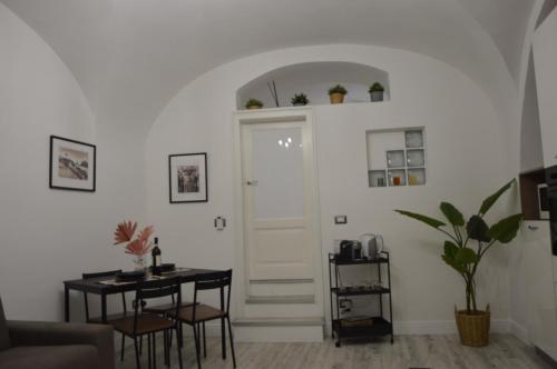 un soggiorno con tavolo e porta bianca di MOUSUITE a Catania