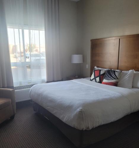 a bedroom with a large bed and a large window at The Kanata Bonnyville in Bonnyville
