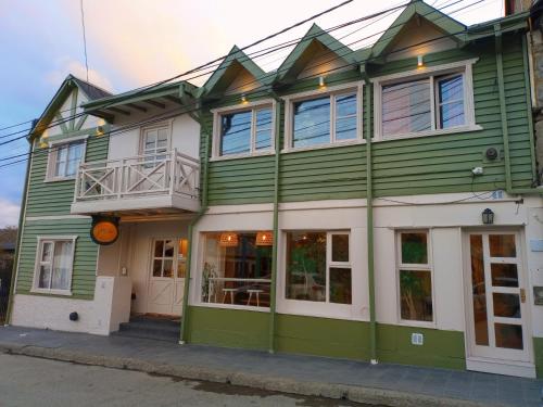 a green house with white trim on a street at Los Calafates Hotel in Ushuaia