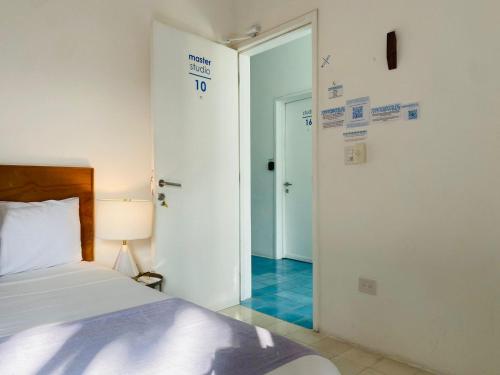 a bedroom with a bed and a door to a hallway at Studios Downtown Cancun in Cancún