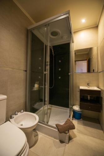a bathroom with a shower and a toilet and a sink at Los Calafates Hotel in Ushuaia