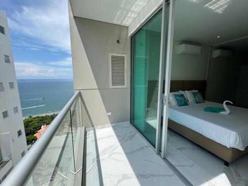 a bedroom with a view of the ocean from a balcony at Bello Horizonte-sector Hilton -irotama in Playa Bello Horizonte