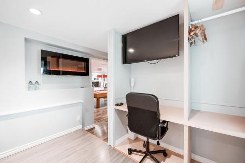 a room with a desk with a monitor and a chair at Along River Ridge in Calgary