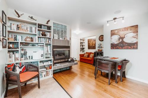 a living room with a table and chairs and a fireplace at Along River Ridge in Calgary