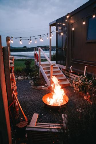 a fire in a bowl in front of a house at Beach Front Oasis - Catlins, Jacks Bay in Hinahina