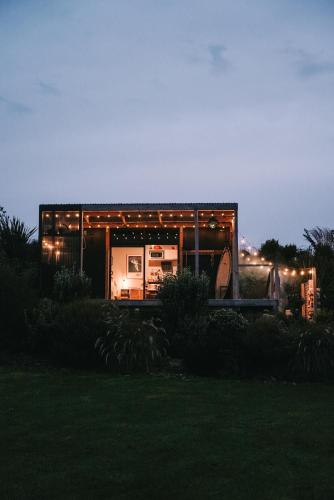 a house is lit up at night with lights at Beach Front Oasis - Catlins, Jacks Bay in Hinahina