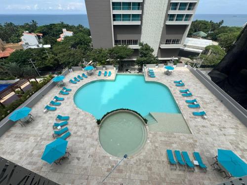 an overhead view of a swimming pool with blue chairs and chairs at Bello Horizonte-sector Hilton -irotama in Playa Bello Horizonte