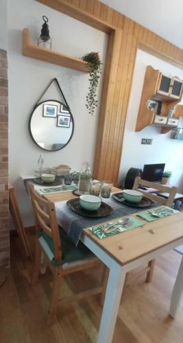 a dining room with a table and a mirror at Mira Moleta bienvenidos a Canfranc in Canfranc-Estación