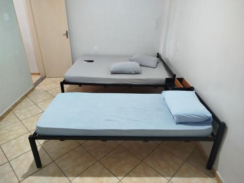 two beds sitting in a room with a wall at Apto 6 ótimo local próximo shopping in Campo Grande