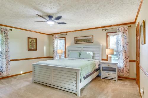 a bedroom with a white bed and a ceiling fan at House on 20 Acres with On-Site Pond in Spring Lake! in Spring Lake