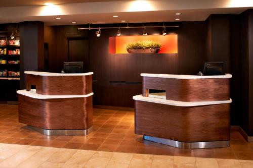 a lobby with two counters and a painting on the wall at Courtyard Toledo Rossford/Perrysburg in Rossford