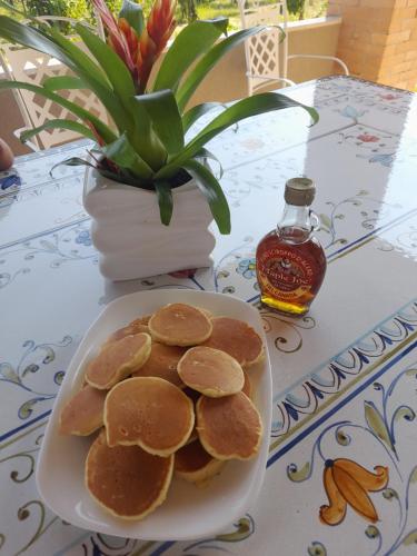 a plate of pancakes on a table with a bottle of syrup at Terra Vitale in Cava deʼ Tirreni
