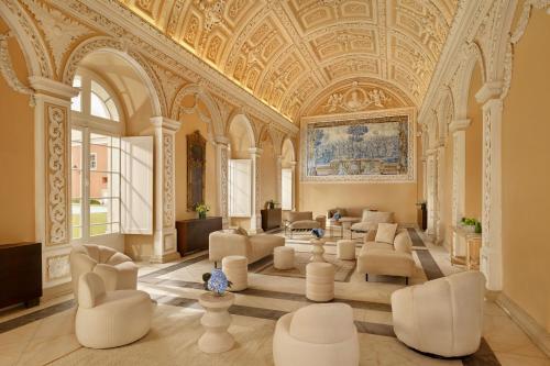 a large room with white chairs and a ceiling at Penha Longa Resort in Sintra