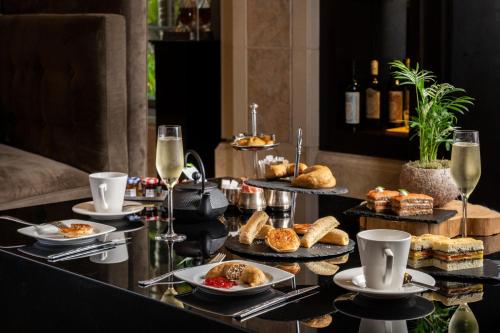 a table with plates of food and glasses of wine at Penha Longa Resort in Sintra