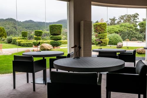 a restaurant with tables and chairs and a view of a garden at Penha Longa Resort in Sintra