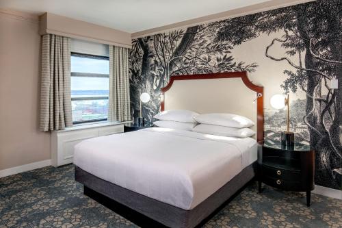 a bedroom with a large bed with a tree wallpaper at Peoria Marriott Pere Marquette in Peoria