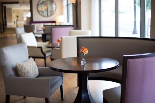 a table and chairs with a vase of flowers on it at Peoria Marriott Pere Marquette in Peoria
