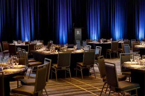 a set of tables and chairs in a room with blue curtains at Renaissance Tampa International Plaza Hotel in Tampa