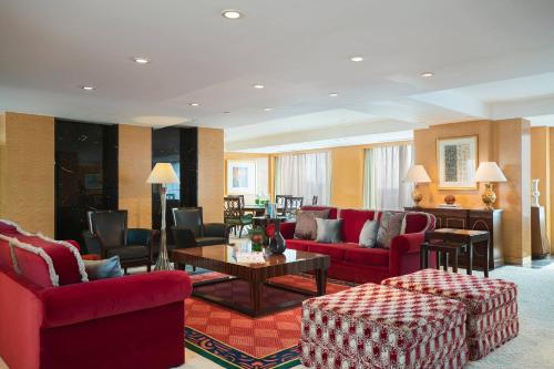 a living room with red furniture and a table at Renaissance Tianjin TEDA Convention Centre Hotel in Binhai