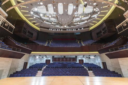 an auditorium with a large chandelier and blue seats at Renaissance Tianjin TEDA Convention Centre Hotel in Binhai