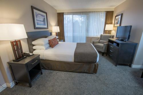 a hotel room with a bed and a television at The Embassy Inn in Victoria