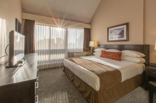 a hotel room with a bed and a television at The Embassy Inn in Victoria