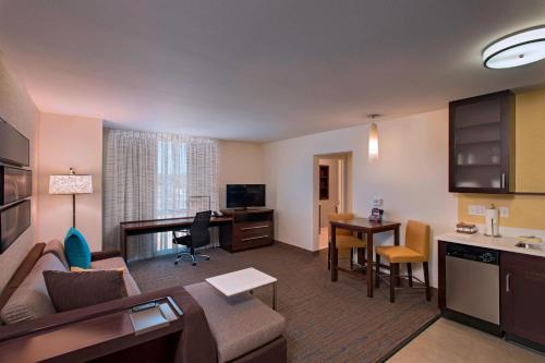 a living room with a couch and a dining room at Residence Inn by Marriott Jackson The District at Eastover in Jackson
