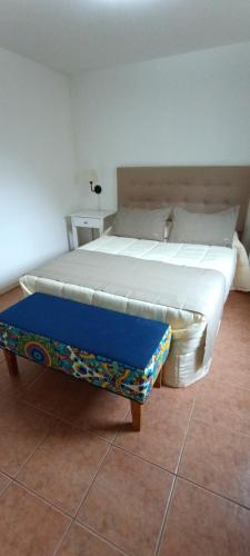ein Bett in einem Zimmer mit einer blauen Bank daneben in der Unterkunft Aparts Casas Del Centro-El Chaltén in El Chalten