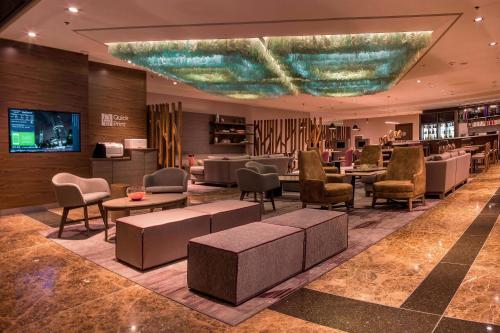 a hotel lobby with chairs and tables and a bar at Courtyard by Marriott Mexico City Revolucion in Mexico City