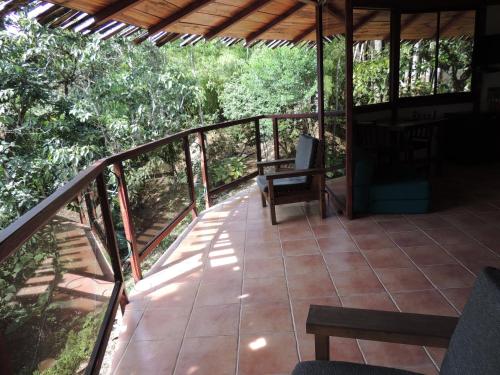 a balcony of a house with a table and chairs at Cascata Del Bosco Cabinas in San Vito